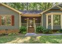 Welcoming front porch with brick steps, a covered entry, and decorative landscaping at 8409 Crowder Rd, Raleigh, NC 27603