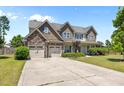 Charming two-story home featuring a stone facade, multi-car garage and a well-manicured lawn at 870 Kentucky Derby Ln, Lillington, NC 27546