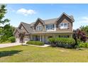 Charming two-story home featuring a stone facade, multi-car garage and a well-manicured lawn at 870 Kentucky Derby Ln, Lillington, NC 27546