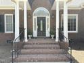 Elegant front entrance features brick steps, white columns, and a custom door with glass accents at 8733 Crowder Rd, Raleigh, NC 27603