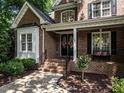 Close up of the brick home's front entrance with well-manicured landscaping and charming details at 91 E Walker Woods Ln, Clayton, NC 27527