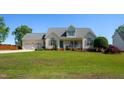 Charming two-story home with a manicured lawn, covered porch, and a two-car garage at 1009 Open Field Dr, Garner, NC 27529
