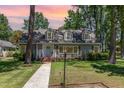 Charming two-story home with a landscaped front yard and dormer windows at sunset at 103 E Meadowbrook Dr, Smithfield, NC 27577