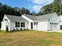 Beautiful home with attached garage, manicured lawn, and black shutters on the windows at 107 Earnest Way, Kenly, NC 27542