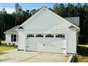 This home boasts a well-maintained two-car garage with black hardware and white siding at 107 Earnest Way, Kenly, NC 27542
