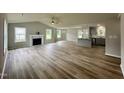 Spacious open-concept living room with a fireplace, wood flooring, and access to the kitchen at 107 Earnest Way, Kenly, NC 27542