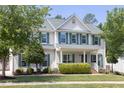 Charming two-story home featuring light siding, green shutters, a manicured lawn and mature landscaping at 110 Stoney Dr, Durham, NC 27703