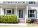 Inviting front porch with red brick steps, decorative greenery, a glass front door and craftsman style columns at 110 Stoney Dr, Durham, NC 27703