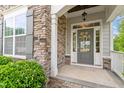 Inviting front entrance featuring stone accents, decorative wreath, and stylish gray door at 113 Old Ballentine Way, Holly Springs, NC 27540