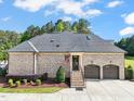Rear exterior showcasing brick detail, two-car garage, and an American flag waving gently at 120 Lu Tom Ln, Wendell, NC 27591