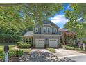 Two-story home with an attached two-car garage, surrounded by lush greenery and mature trees at 1201 Red Beech Ct, Raleigh, NC 27614