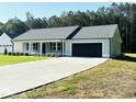 Attractive single-story home featuring a spacious driveway and attached two-car garage at 121 Earnest Way, Kenly, NC 27542