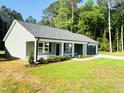 Inviting single-story home boasts fresh landscaping, a covered porch, and an attached garage at 121 Earnest Way, Kenly, NC 27542