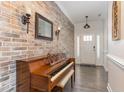 Inviting entryway with decorative brick wall, complemented by wood floors and a white front door at 123 Jonalker Ct, Clayton, NC 27520