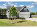 Charming two-story home featuring a manicured lawn, a two-car garage, and modern architectural details at 123 Jonalker Ct, Clayton, NC 27520