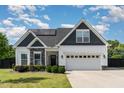 Charming two-story home featuring a mix of siding, stone accents, and a well-manicured lawn at 123 Jonalker Ct, Clayton, NC 27520