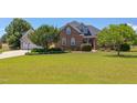 Charming brick home with a lush green lawn and mature trees creating lovely curb appeal at 130 Skipwith Dr, Wendell, NC 27591