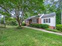 This well-maintained home is surrounded by lush landscaping and vibrant green grass at 1313 Ridge Rd, Raleigh, NC 27607