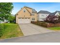 Rear exterior featuring a two-car garage and spacious driveway, enclosed by a decorative wooden fence at 1328 Palace Garden Way, Raleigh, NC 27603