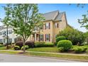 Two-story home with manicured landscaping, colorful bushes, and a mature shade tree in the front yard at 1328 Palace Garden Way, Raleigh, NC 27603