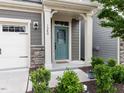 Close-up view of the inviting front door with sidelights and decorative stone accents at 1380 Channing Park Cir, Cary, NC 27519