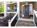 Inviting front porch with brick steps, black railings, and stylish decor including wreath and floral arrangements at 1424 Forest Fern Ln, Fuquay Varina, NC 27526