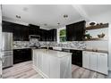 Modern kitchen featuring dark cabinets, a center island with light countertops, and stainless steel appliances at 1424 Forest Fern Ln, Fuquay Varina, NC 27526