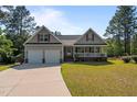Traditional home featuring a two-car garage, inviting front porch, and manicured lawn at 15 Clearwater Harbour Hbr, Sanford, NC 27332