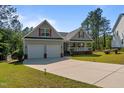 Traditional home featuring a two-car garage, inviting front porch, and manicured lawn at 15 Clearwater Harbour Hbr, Sanford, NC 27332