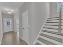 The foyer boasts hardwood floors, white trim and a staircase leading to the upper level at 1665 Wilde Bnd, Apex, NC 27523