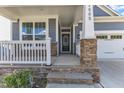 Inviting front porch with stone accents on the support beams leading to the home's entryway at 1665 Wilde Bnd, Apex, NC 27523