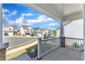 View from the porch showcasing the sidewalk lined with well-maintained homes and beautiful landscaping at 1665 Wilde Bnd, Apex, NC 27523