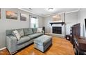 Inviting living room with brick fireplace, cozy sofa, ottoman, and hardwood flooring, creating a comfortable space at 1700 Laura Duncan Rd, Apex, NC 27502
