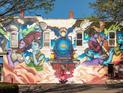 Outdoor mural featuring a vibrant train and figures adorning an exterior wall at 200 Byrum St # 1, Cary, NC 27511
