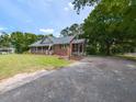 Side view of the house with a screened in porch and a gravel driveway at 235 Stephenson Rd, Benson, NC 27504