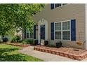 Charming home featuring blue shutters, decorative landscaping, and a welcoming front entrance with glass storm door at 2412 Chartwell Ln, Graham, NC 27253