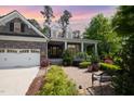 Charming stone home with a two-car garage and an inviting front porch, surrounded by professionally landscaped gardens at 2421 Beckwith Rd, Apex, NC 27523