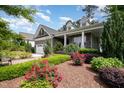 Beautifully landscaped front yard showcasing a stone home with a two-car garage and welcoming front porch at 2421 Beckwith Rd, Apex, NC 27523