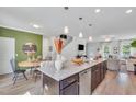 Open-concept kitchen featuring an island with bar seating, seamlessly flowing into the dining and living areas at 287 Alice Trace Place, Angier, NC 27501
