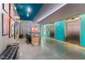 Modern lobby features colorful art, concierge desk, elevators, and sleek, polished concrete floors at 319 Fayetteville St, Raleigh, NC 27601