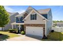 Attractive two-story home featuring stone accents, blue shutters, an attached two-car garage, and professional landscaping at 3936 White Kestreg Dr Dr, Raleigh, NC 27616