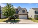 Charming two-story home featuring stone accents, blue shutters, a well-manicured lawn, and an attached two-car garage at 3936 White Kestreg Dr Dr, Raleigh, NC 27616