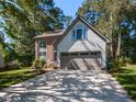 Charming two-story home with siding and brick exterior, manicured lawn, and attached two-car garage at 404 Woodstar Dr, Cary, NC 27513