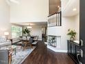 Bright, open-concept living room with dark wood floors, dining area, and a two-story foyer at 404 Woodstar Dr, Cary, NC 27513