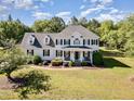 Beautiful two-story home with a lush green lawn, mature trees, and a charming front porch at 4117 Stansted Dr, Fuquay Varina, NC 27526