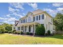 Spacious two-story home featuring black shutters, a covered front porch, and verdant landscaping at 4117 Stansted Dr, Fuquay Varina, NC 27526