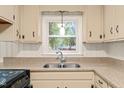 Kitchen sink with granite countertop and a window view, creating an appealing workspace at 413 Winterlochen Rd, Raleigh, NC 27603