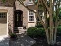 Inviting front entrance featuring a decorative glass door, brick steps, and lush landscaping at 4143 Gardenlake Dr, Raleigh, NC 27612