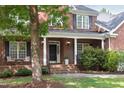 Close up of a brick home's front door with a small porch and beautiful landscaping at 4913 Stockton Way, Durham, NC 27707