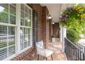 Relaxing front porch with chair, flowers and a view of the brick exterior at 4913 Stockton Way, Durham, NC 27707